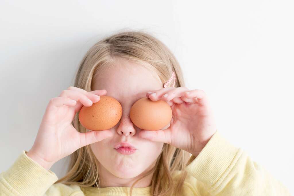 Girl holding up two eggs