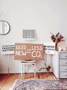 sign saying less new equals less CO2