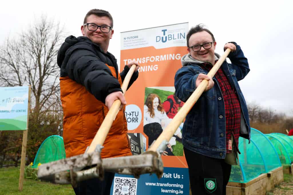 Two men holding gardening tools in the Blanchardstown garden